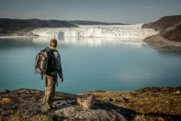 A Hiker Near The Eqi Glacier In North Greenland