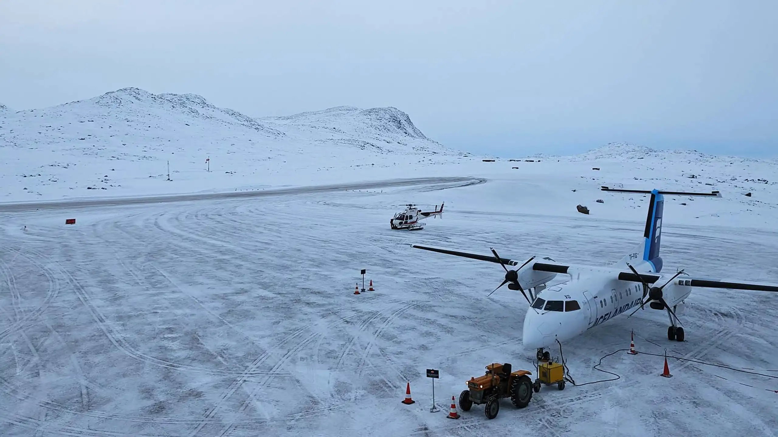 Icelandair Dash-8 FI103 landed  11.51 a.m in Kulusuk. Greenland Copter waiting for the pilot Photo: Jesper Nymand, AFIS i Kulusuk