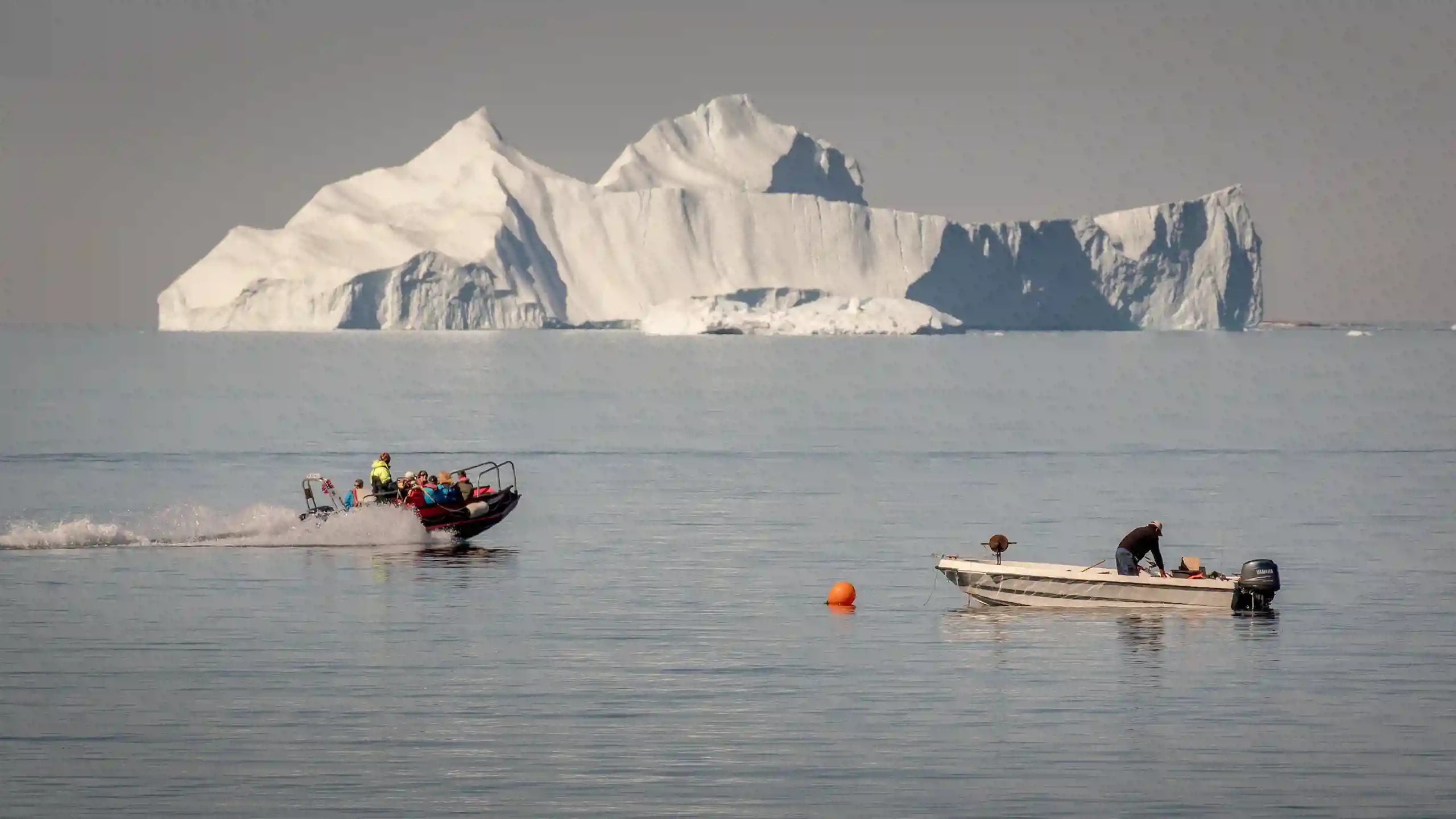 A Tenderboat From MS Fram Going Past A Fisherman At Work In Upernavik In Greenland