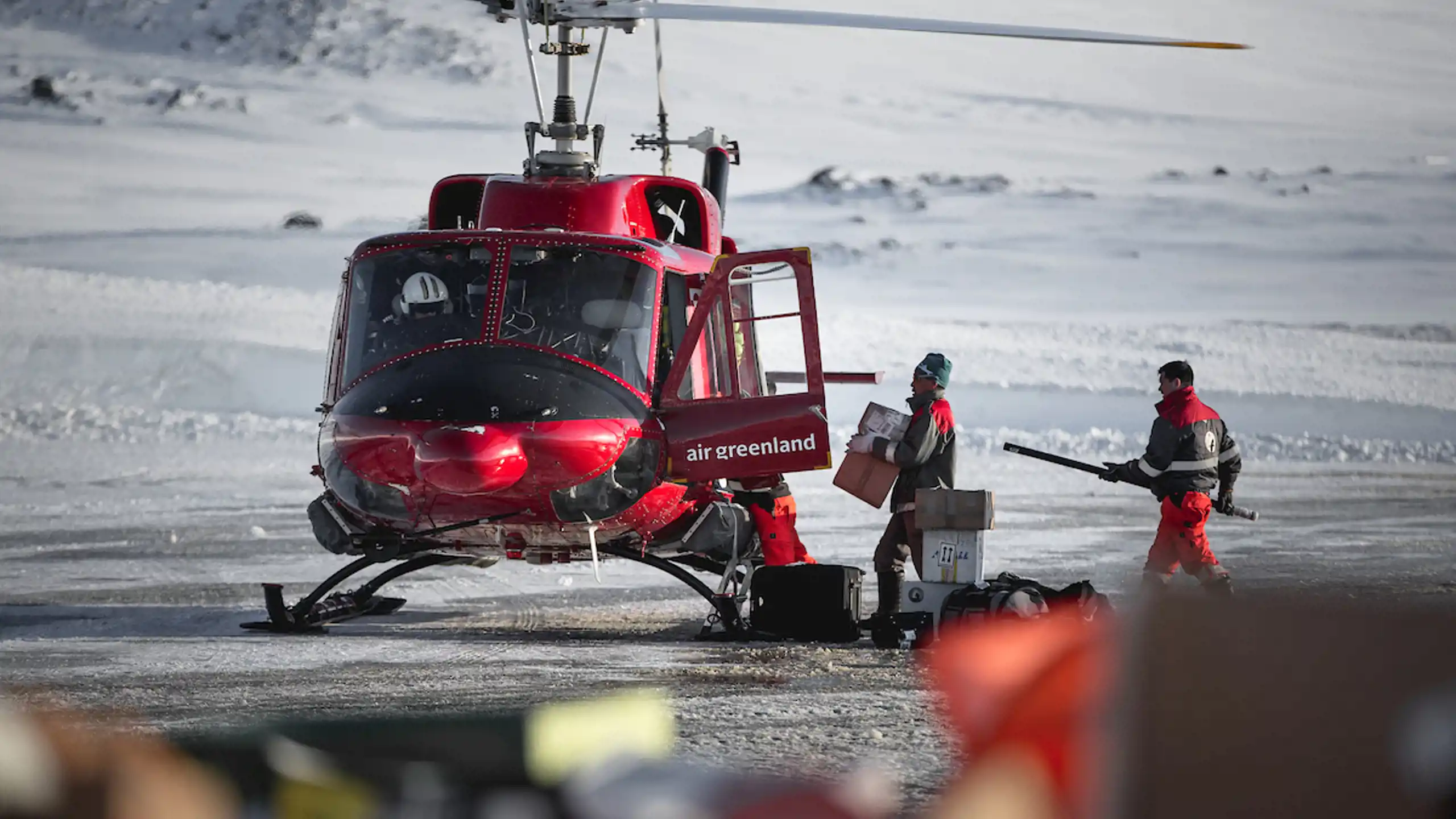 Airport Personnel Loading An Air Greenland Bell 212 Passenger Helicopter In Kulusuk Airport, East Greenland