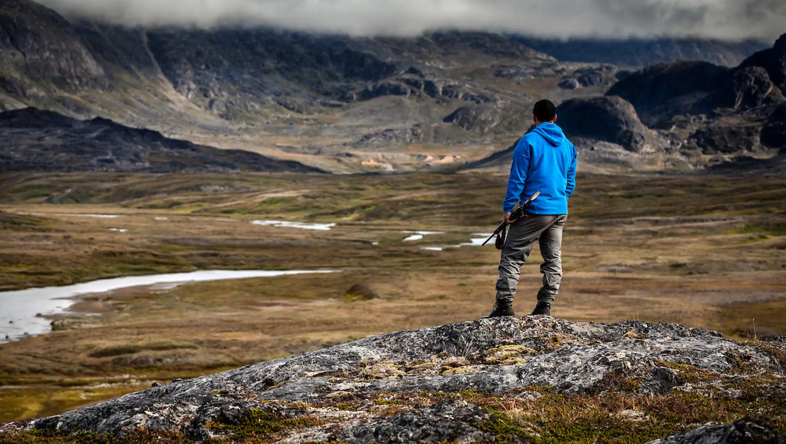 A Hunter Overlooking The River Valley Of Erfalik In Greenland